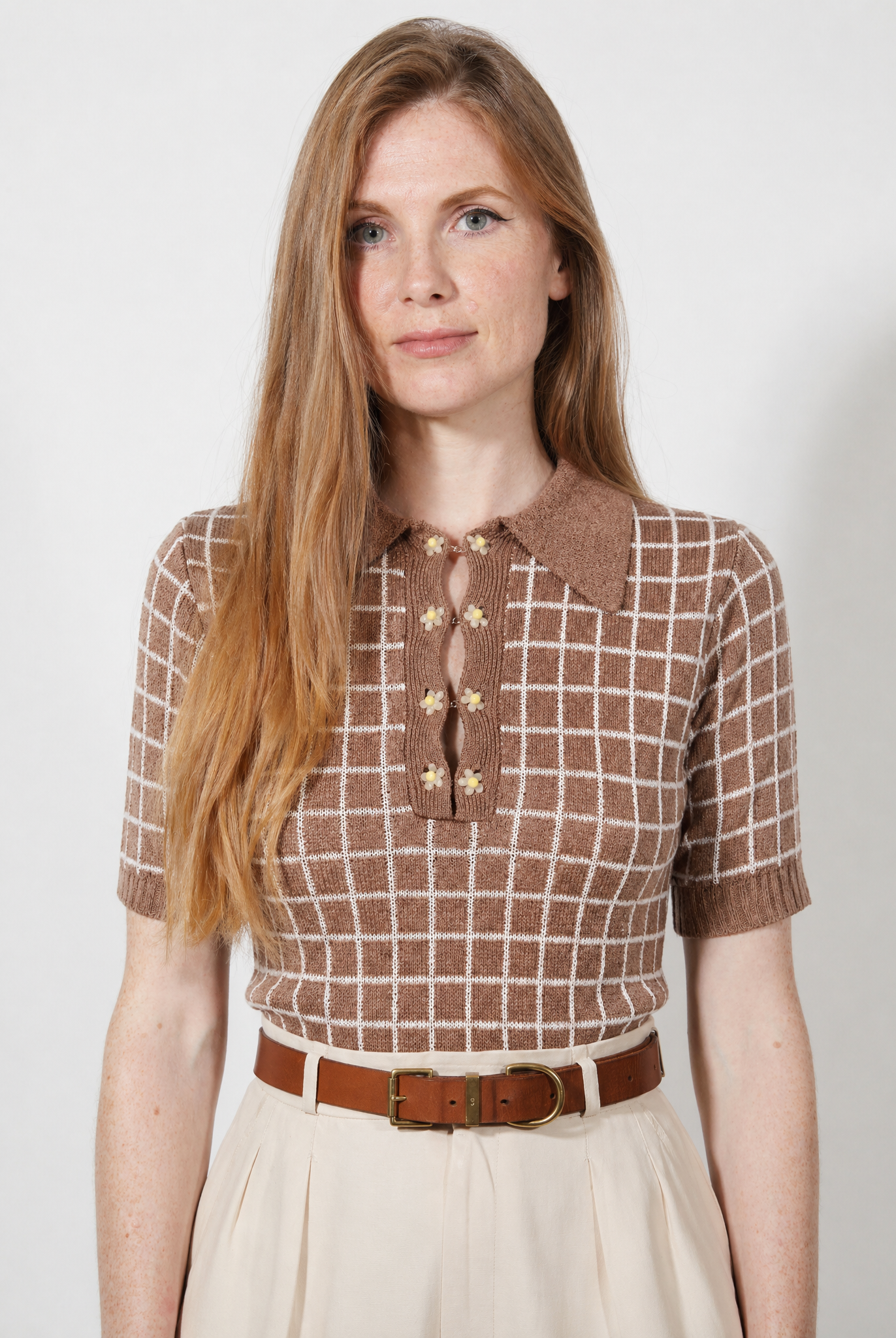 Combelle Madison Top in tobacco, front view showing the warm two-tone check pattern and daisy chain cufflink buttons, styled with cream wide-leg trousers and a tan belt