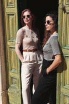 Combelle Alix Top lifestyle shot, two models lounging in green doorway wearing fawn and black colourways