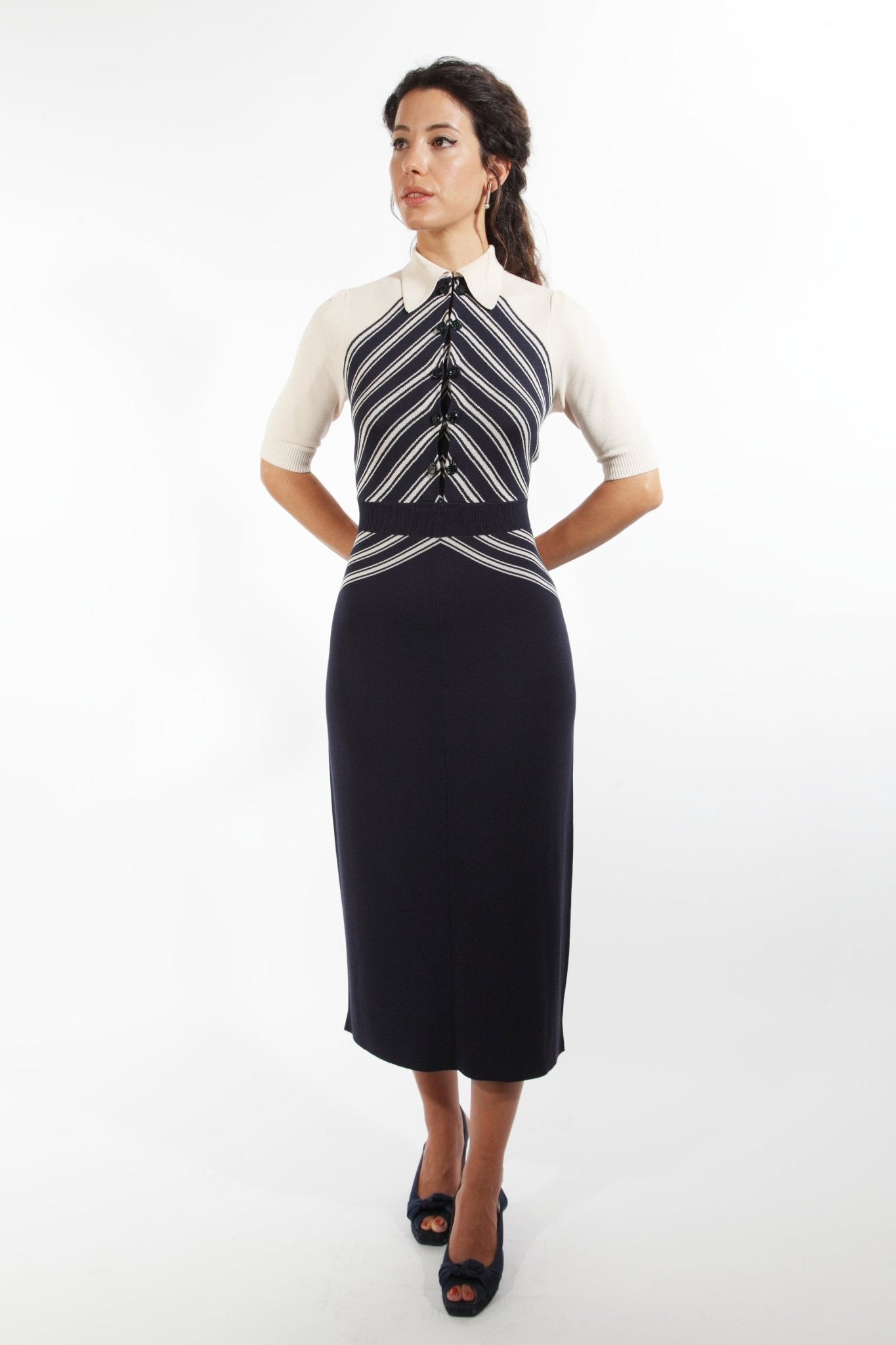 Combelle Colbert Dress full-length front view with hands behind back, diagonal stripe knit bodice with dark pencil skirt