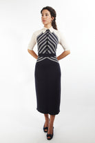 Combelle Colbert Dress full-length front view with hands behind back, diagonal stripe knit bodice with dark pencil skirt