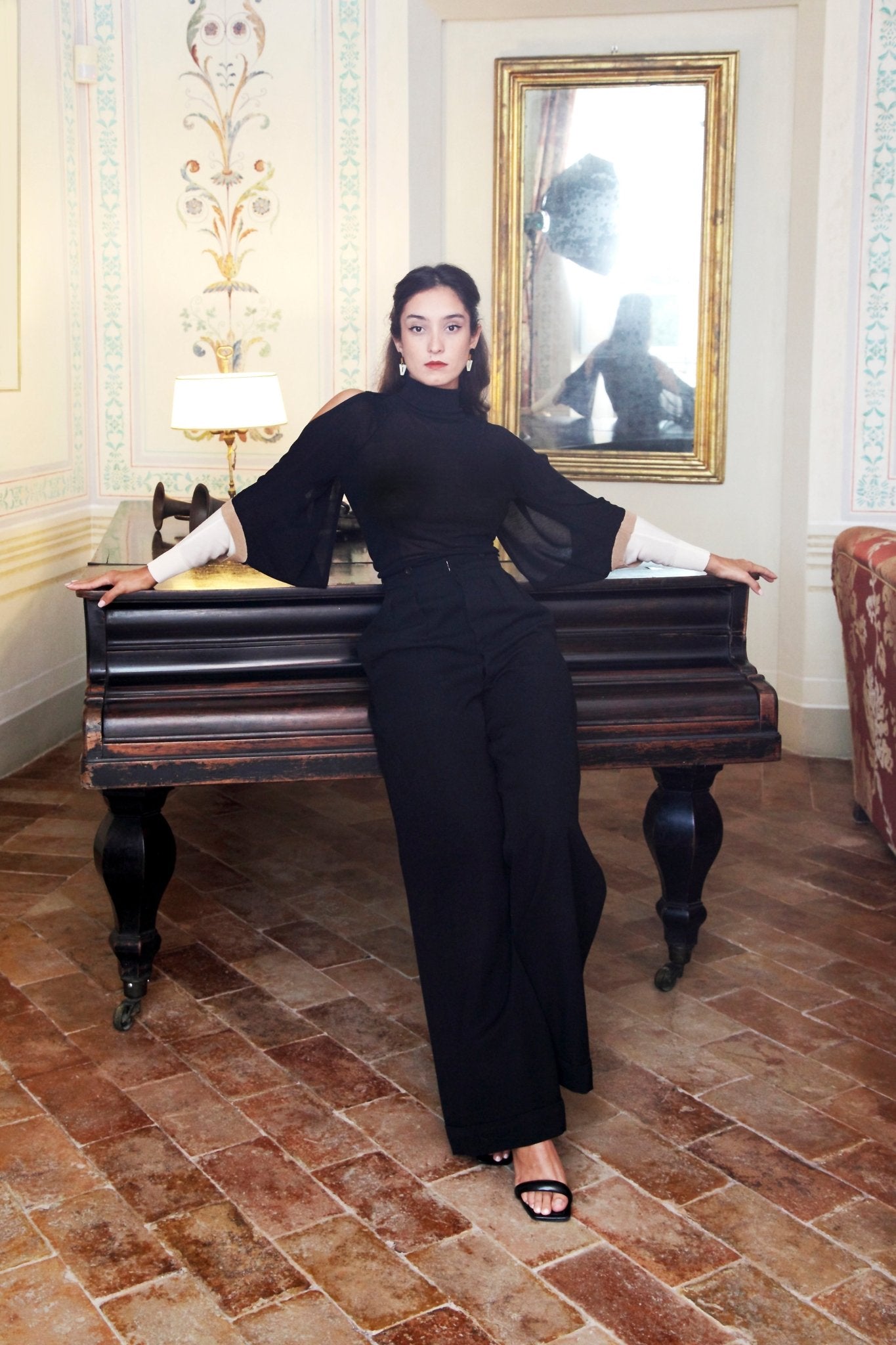 Combelle Elsa Top in black, full length front view in a grand interior setting showing the complete silhouette