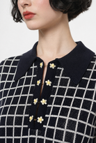 Combelle Madison Top in navy, upper body close-up showing the polo collar and daisy chain cufflink buttons against the two-tone check