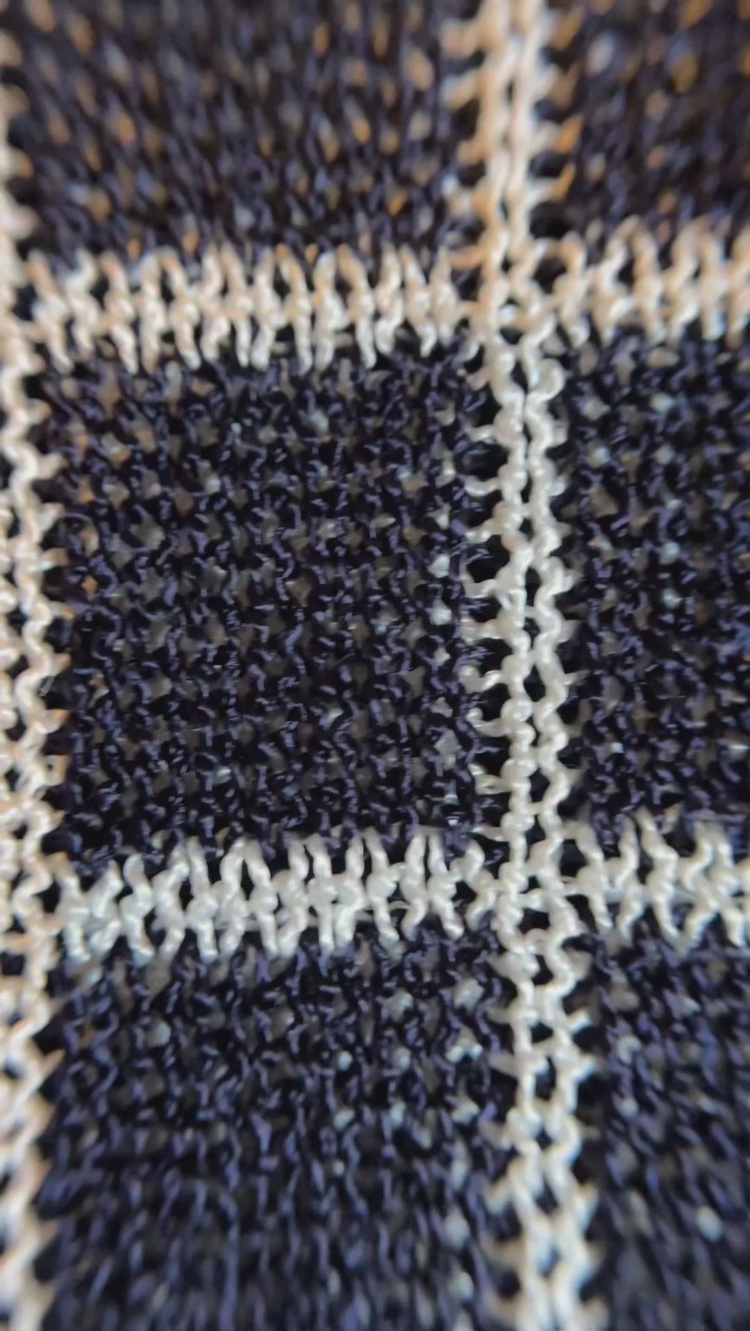 Combelle Madison Top navy macro detail video showing the two-tone viscose yarn texture, check pattern, polo collar and daisy chain buttons