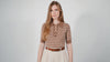 Combelle Madison Top in tobacco worn by a model in a white studio, front upper body crop, slowly panning in as she blinks and runs her fingers through her hair before turning and walking out of frame